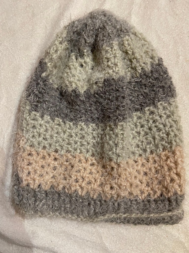 Light grey, white, and pink crochet slouch hat on a white background.